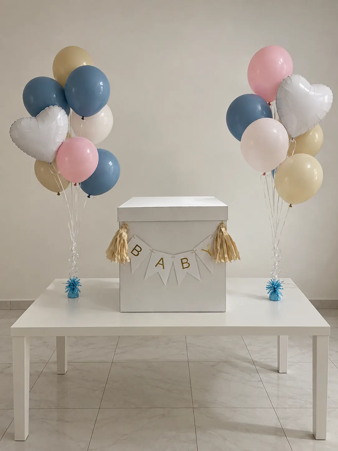 Mesa con caja de regalos y bouquets de globos en tonos pastel
